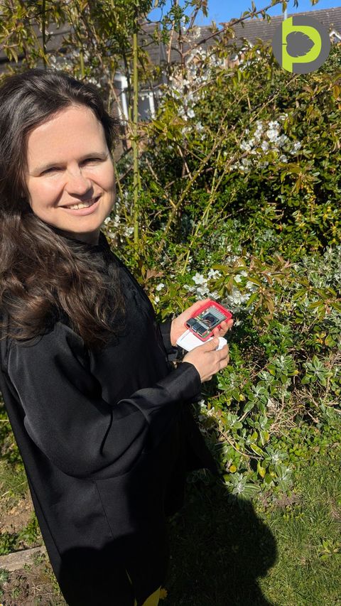 A Petiole Pro researcher holding a Raspberry Pi single-board computer in a garden, illustrating edge hardware for on-device plant analysis.