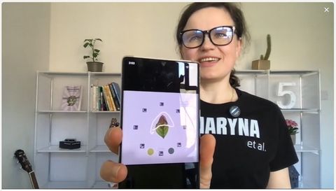 Dr Maryna Kuzmenko holding a phone that shows the Petiole Pro capture screen with a leaf inside a ring of ArUco calibration markers.