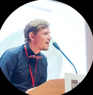 Portrait of Andrii Seleznov, co-founder and Chief Technology Officer of Petiole, speaking at a conference.